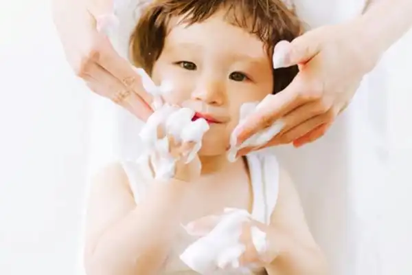 پس از مرطوب کردن دست و صورت کودک مایع را با حرکت دَوَرانی انگشتان، به آرامی روی پوست ماساژ دهید.